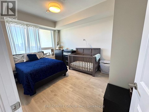 A bedroom with a blue bedspread and a baby crib.