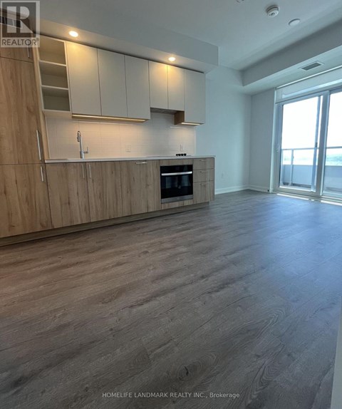 A spacious kitchen with wooden cabinets and a stainless steel oven.