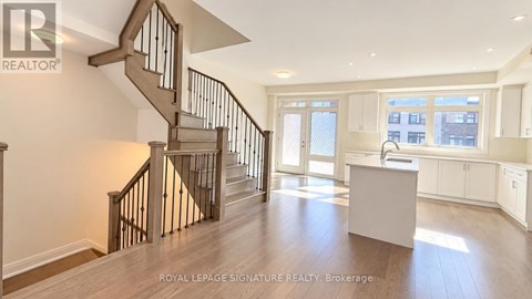 A spacious room with a staircase and a desk.