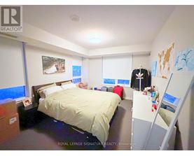 A bedroom with a bed, a desk, and a closet.