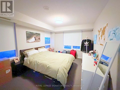 A bedroom with a bed, a desk, and a closet.