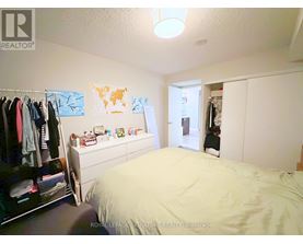 A bedroom with a bed, a wardrobe, and a dresser.