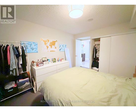 A bedroom with a bed, a wardrobe, and a dresser.