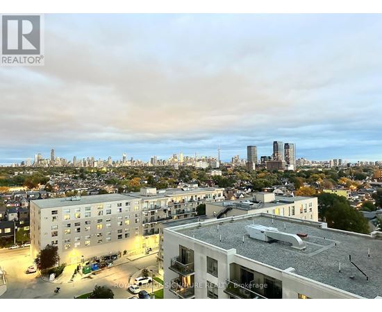 A cityscape with buildings and a cloudy sky.