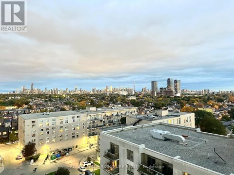 A cityscape with buildings and a cloudy sky.