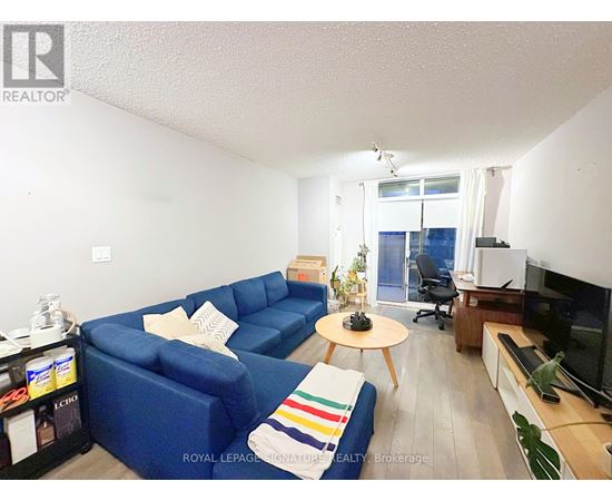 A living room with a blue couch, a coffee table, and a television.