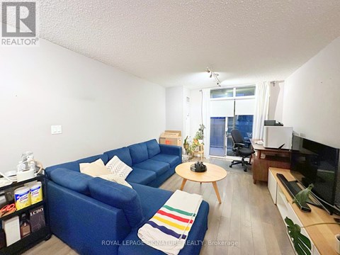 A living room with a blue couch, a coffee table, and a television.