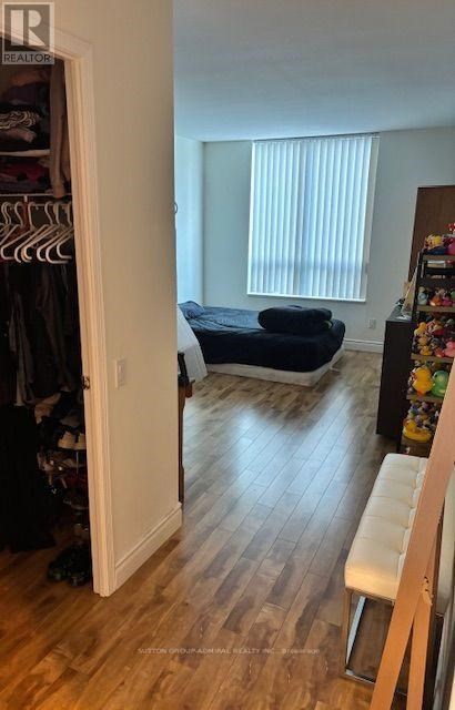 A bedroom with a bed, a wardrobe, and a window with blinds.