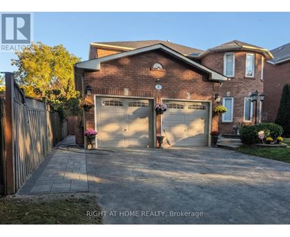A brick house with a garage door and a sign that says "Right at Home Realty, Brokerage".