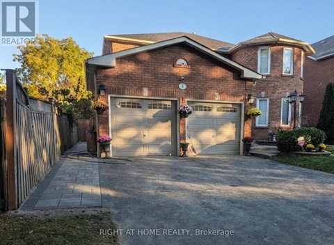 A brick house with a garage door and a sign that says "Right at Home Realty, Brokerage".