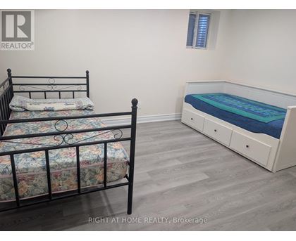 A bedroom with a black metal bed frame and a white bed with a blue mattress.