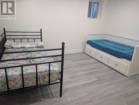 A bedroom with a black metal bed frame and a white bed with a blue mattress.