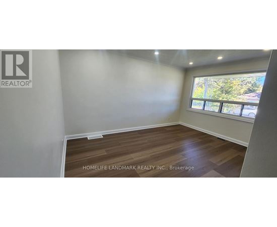 A room with a window and wooden flooring is for sale.