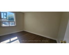 A room with a window and wooden flooring.