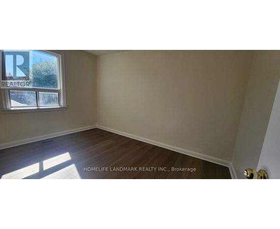 A room with a window and wooden flooring.