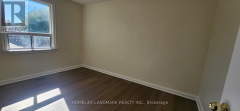 A room with a window and wooden flooring.