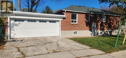 A garage with a white door is in front of a brick house.