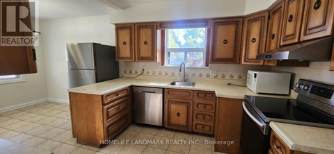 A kitchen with wooden cabinets and a refrigerator.