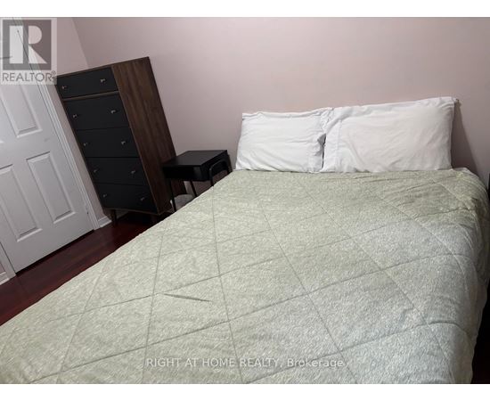 A bed with a white pillow and a green blanket is in the foreground of the image.