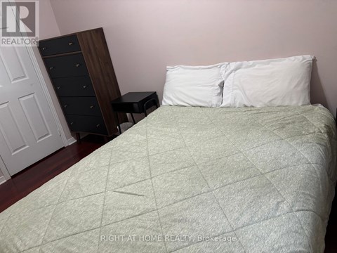 A bed with a white pillow and a green blanket is in the foreground of the image.