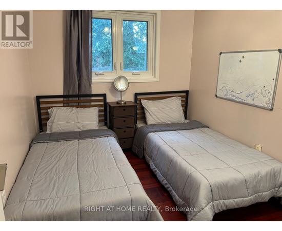 Two twin beds in a room with a whiteboard on the wall.