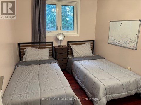 Two twin beds in a room with a whiteboard on the wall.