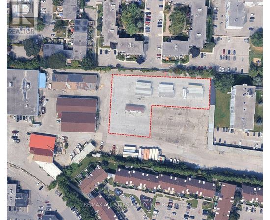 A large empty lot is surrounded by apartment buildings.