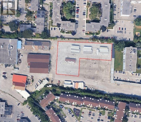 A large empty lot is surrounded by apartment buildings.