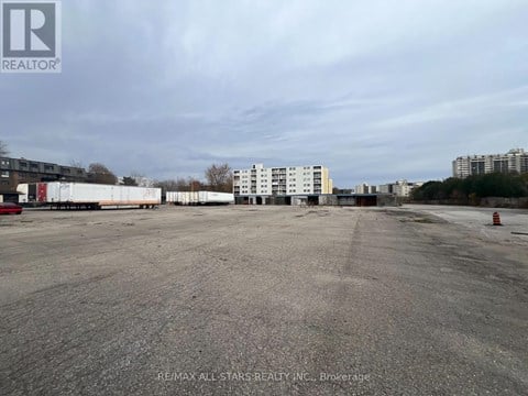 A large, empty parking lot with a building in the background.