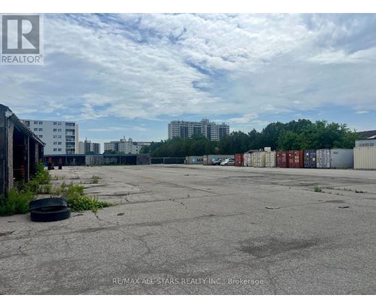 A large, empty parking lot with a few buildings in the background.