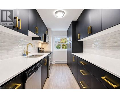A modern kitchen with black cabinets and gold handles.
