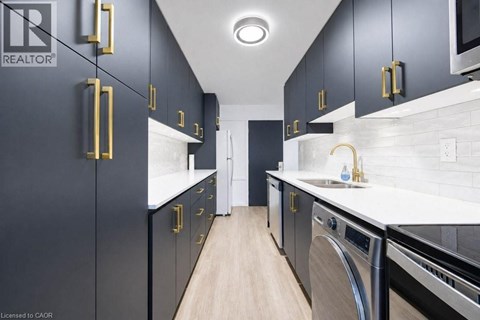 A modern kitchen with black cabinets and gold handles.