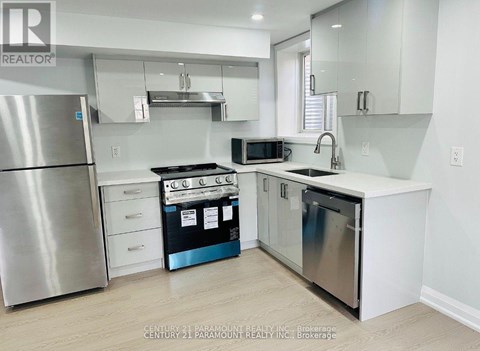 A kitchen with white cabinets and a stainless steel refrigerator.