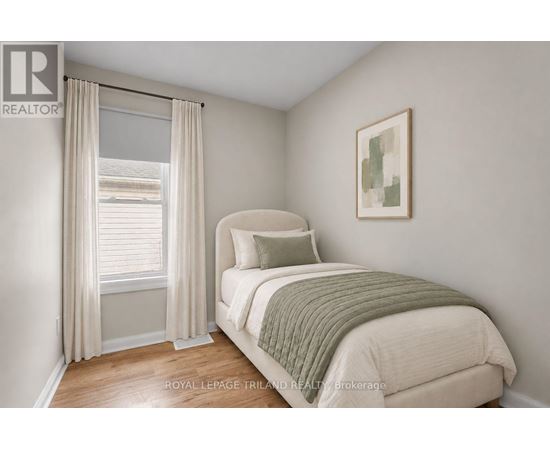 A bedroom with a bed, pillow, and a window with curtains.
