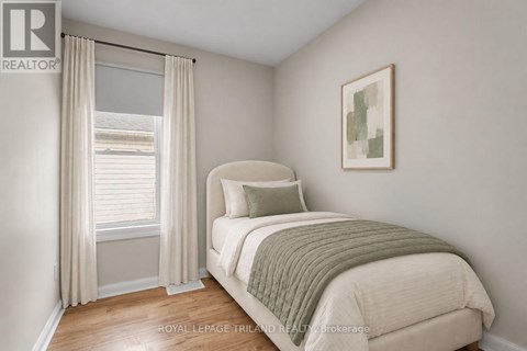 A bedroom with a bed, pillow, and a window with curtains.