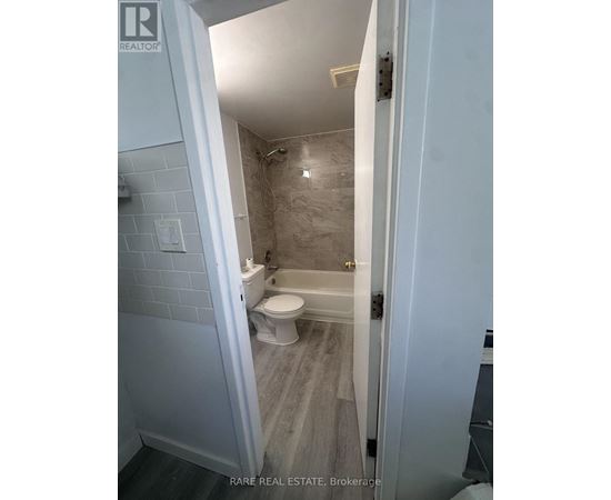 A bathroom with a toilet, tub, and sink.