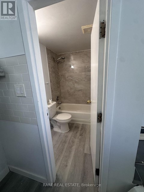 A bathroom with a toilet, tub, and sink.