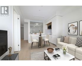 A modern living room with a white sofa, a glass table, and a television.