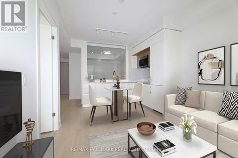 A modern living room with a white sofa, a glass table, and a television.