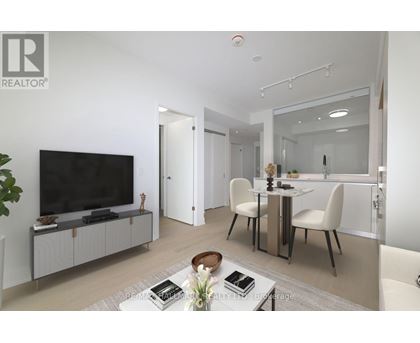 A modern living room with a television, dining table, and chairs.