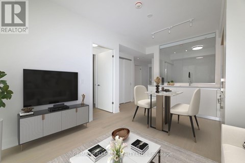A modern living room with a television, dining table, and chairs.