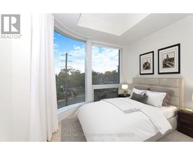A bedroom with a large bed and a view of the street outside.