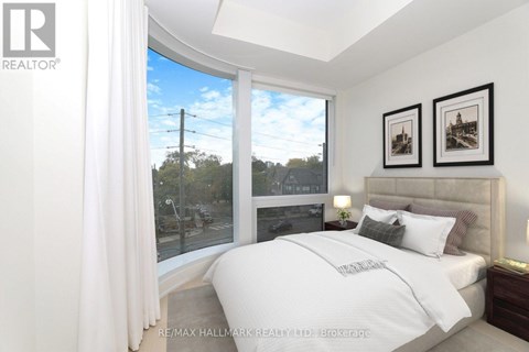 A bedroom with a large bed and a view of the street outside.