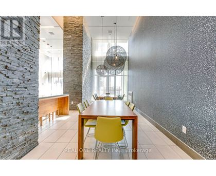 A dining room with a stone pillar and a wooden table.