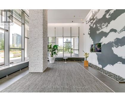 A modern living room with a grey carpet and a large grey and white mural on the wall.