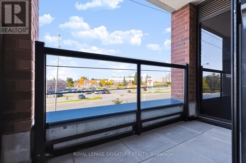 A balcony with a view of a parking lot and trees.