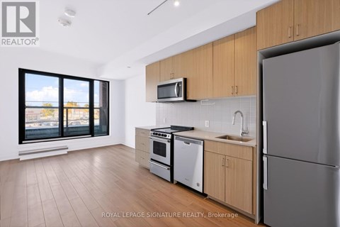 A modern kitchen with wooden cabinets and stainless steel appliances.