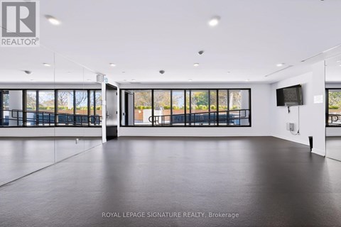 A spacious room with a large window and a flat screen TV mounted on the wall.