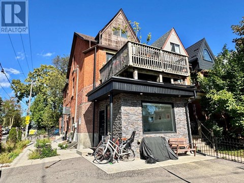 A house with a balcony and a bicycle parked in front.