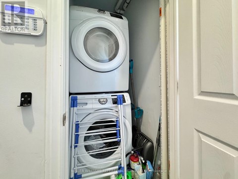 A white washing machine is in a small space between a door and a wall.